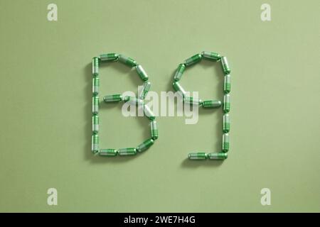 Mise en page créative de pilules et de capsules colorées sur fond pastel. Concept médical minimal formant la forme B9. Vue à plat Banque D'Images