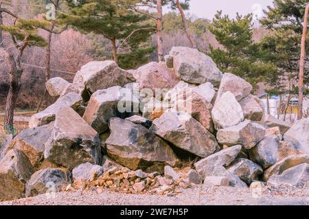 Gros plan d'un grand tas de rochers dans la campagne avec des arbres à feuilles persistantes en arrière-plan en Corée du Sud Banque D'Images