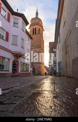 Vue le long de la rue pavée à une tour d'église entre les bâtiments traditionnels au crépuscule, Weil der Stadt, Allemagne Banque D'Images