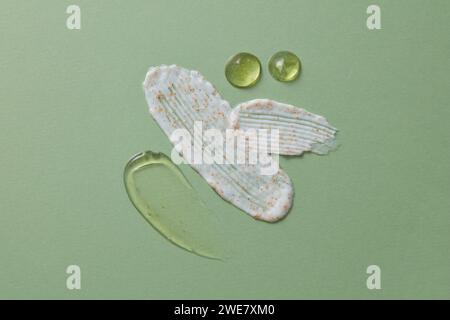 Frottis crème blanche mélangés à quelques particules oranges, décorés de quelques gouttes d'essence jaune. Concept pour cosmétique de soin de la peau Banque D'Images