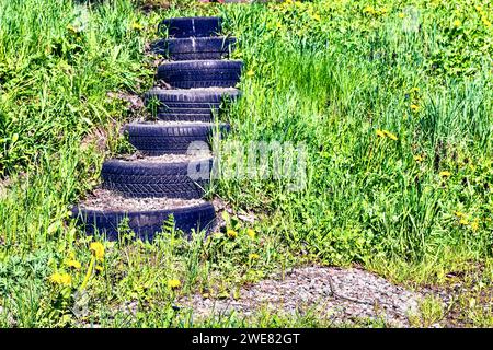 Les escaliers dans le jardin sont fabriqués à partir de vieux caoutchouc de voiture. Banque D'Images