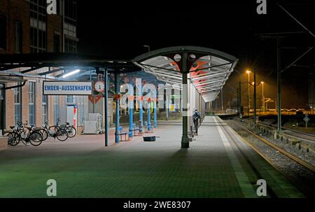 Emden, Allemagne. 24 janvier 2024. Une valise renversée par le vent se trouve sur le quai de la gare Emder-Ausenhafen. Un passager attend un train. Crédit : Lars Penning/dpa/Alamy Live News Banque D'Images