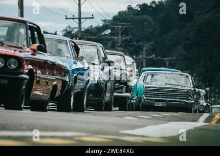 Thames, Nouvelle-Zélande, 25 mars 2021, Whangamata Beach Hop rallye : une ligne de voitures anciennes classiques sur la route. Banque D'Images