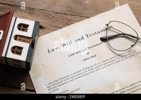 Last Will et Testament, modèle de maison et verres sur table en bois, gros plan Banque D'Images