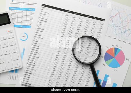 Documents comptables, loupe et calculatrice sur table, vue de dessus Banque D'Images