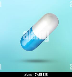 Capsule de vitamine colorée dans l'air sur fond bleu clair Banque D'Images