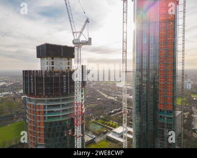 Image aérienne près des tours résidentielles Blade et Three60 à Manchester, Royaume-Uni, en construction, montrant un revêtement, un cadre en béton et des grues Banque D'Images