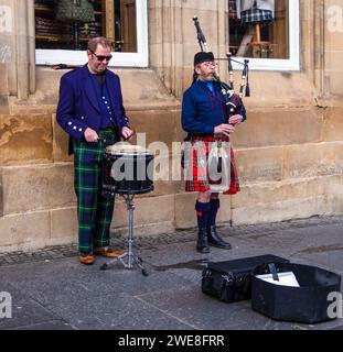 Musiciens de rue jouant, l'un de la cornemuse et l'autre jouant d'un tambour-piège dans un cadre urbain Royal Mile Edinburgh. Banque D'Images