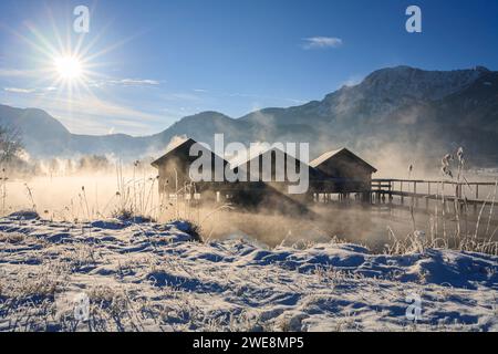 Hangars à bateaux sur le lac en face des montagnes, hiver, neige, lac Kochelsee, haute-Bavière, Bavière, Allemagne, Europe Banque D'Images