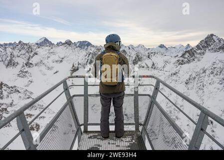 L'homme se tenait à un point de vue dans les Alpes. Snowboarder se dresse sur le fond des Alpes françaises. Hiver dans les alpes françaises. Banque D'Images