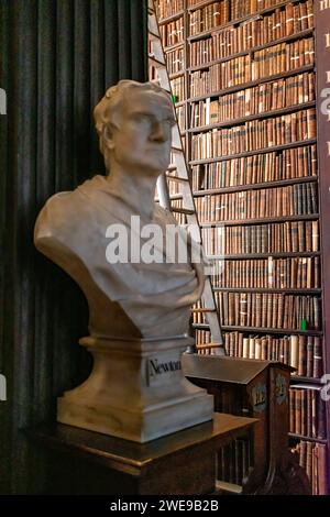 Buste en marbre d'Isaac Newton dans un décor de bibliothèque classique avec des étagères en arrière-plan. Banque D'Images