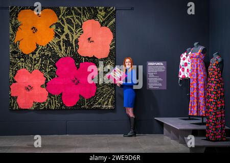 Un assistant de galerie aux côtés d'une tapisserie de laine nouée à la main de 1968 intitulée 'Flowers' lors de l'avant-première presse de The Andy Warhol : The textiles aux Dovecot Studios, Édimbourg. L'exposition montre les œuvres textiles récemment redécouvertes par l'artiste pop américain, marquant la première occasion pour le public de voir ces œuvres en Écosse. Date de la photo : mercredi 24 janvier 2024. Banque D'Images