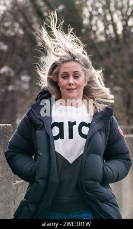Une femme venteuse à Leeds. La tempête Jocelyn a provoqué de nouvelles perturbations dans la majeure partie du Royaume-Uni, moins de deux jours après que la tempête Isha ait fait deux morts et des milliers de sans électricité. Date de la photo : mercredi 24 janvier 2024. Banque D'Images