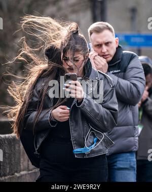 Une femme venteuse à Leeds. La tempête Jocelyn a provoqué de nouvelles perturbations dans la majeure partie du Royaume-Uni, moins de deux jours après que la tempête Isha ait fait deux morts et des milliers de sans électricité. Date de la photo : mercredi 24 janvier 2024. Banque D'Images