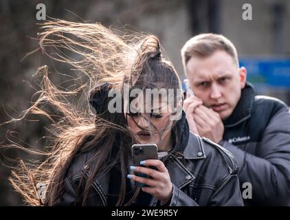 Une femme venteuse à Leeds. La tempête Jocelyn a provoqué de nouvelles perturbations dans la majeure partie du Royaume-Uni, moins de deux jours après que la tempête Isha ait fait deux morts et des milliers de sans électricité. Date de la photo : mercredi 24 janvier 2024. Banque D'Images