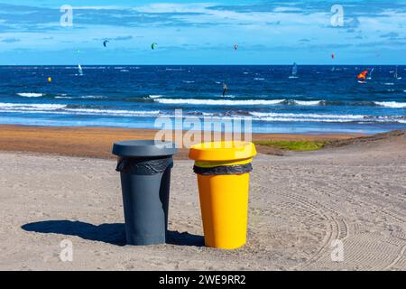 Deux poubelles en plastique sur la plage de sable. Conteneurs à ordures sur la côte de l'océan Banque D'Images