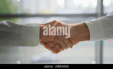 Close up mains caucasiennes secouant formel amical salutation geste de bienvenue embauché inviter bonjour poignée de main serrer les bras palmes homme de partenariat de coopération Banque D'Images
