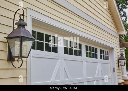 Vintage Lantern et garage blanc sur façade de maison jaune Banque D'Images