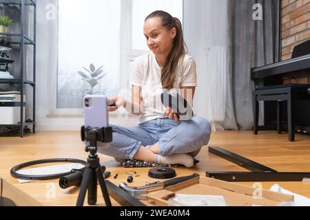 Une fille ne comprend pas comment assembler les meubles et reçoit un soutien à distance Banque D'Images