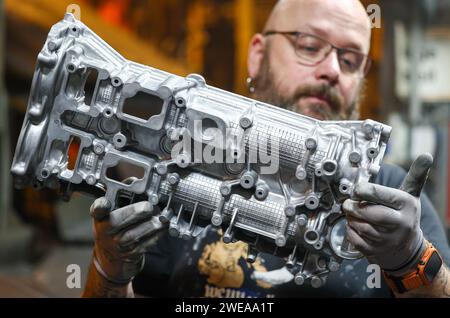 Annaberg Buchholz, Allemagne. 24 janvier 2024. Un employé de Handtmann Leichtmetallgießerei Annaberg GmbH inspecte une pièce moulée en aluminium après la coulée. 328 employés produisent 60 000 tonnes de pièces moulées spéciales sur le site des Monts Ore, principalement pour l'industrie automobile. Fondée en 1926 sous le nom de fonderie DKW, des pièces pour motos MZ ont été produites ici à l'époque de la RDA. Après la réunification, la société a été reprise par le groupe Handtmann de Biberach et a continué à s'étendre. Crédit : Jan Woitas/dpa/Alamy Live News Banque D'Images