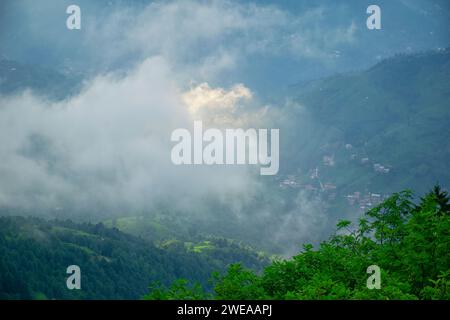 Le coucher du soleil projette les derniers faisceaux de lumière sur le plateau alors qu'une tempête se profile. Un village dans le brouillard sur le plateau. Banque D'Images