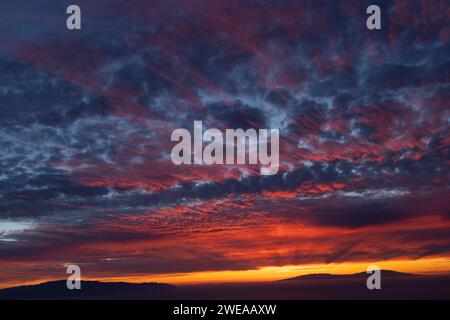 coucher de soleil spectaculaire avec des nuages rouges et oranges comme coups de pinceau dans le ciel. spectacle de la nature. le ciel en flammes Banque D'Images