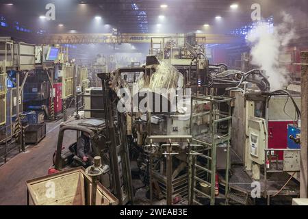 Annaberg Buchholz, Allemagne. 24 janvier 2024. Chez Handtmann Leichtmetallgießerei Annaberg GmbH, un employé remplit une machine de moulage sous pression avec de l’aluminium fondu. 328 employés produisent 60 000 tonnes de pièces moulées spéciales sur le site des Monts Ore, principalement pour l'industrie automobile. Fondée en 1926 en tant que fonderie DKW, des pièces pour motos MZ ont été fabriquées ici à l'époque de la RDA. Après la réunification, la société a été reprise par le groupe Handtmann de Biberach et a continué à s'étendre. Crédit : Jan Woitas/dpa/Alamy Live News Banque D'Images