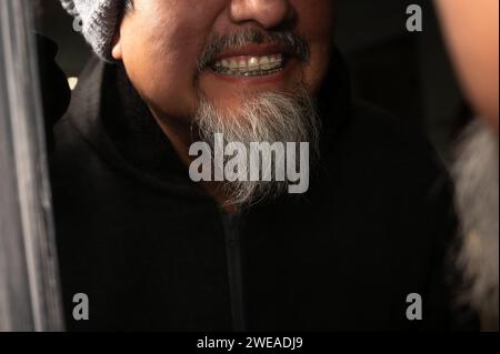 Fermer un bel homme avec une barbe et des bagues sur les dents sourit d'abord au miroir. Banque D'Images