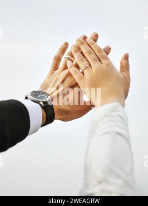 Gros plan de la main de la mariée et du marié portant une bague Banque D'Images
