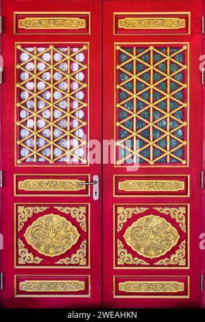Ancienne porte en bois rouge chinois avec porte en sculpture dorée dragon du temple chinois Banque D'Images