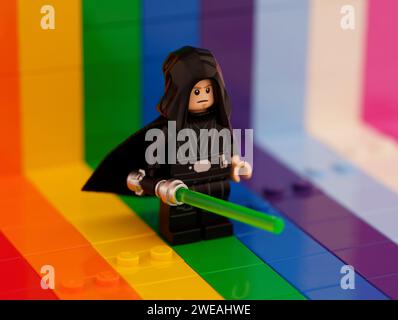 Tambov, Fédération de Russie - 01 octobre 2023 Une minifigurine Lego Luke Skywalker avec un sabre laser sur fond arc-en-ciel. Banque D'Images