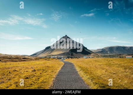 Belle montagne volcanique Stapafell dans le village de pêcheurs Arnarstapi et chemin à travers la prairie dorée dans la péninsule de Snaefellsnes, Islande Banque D'Images
