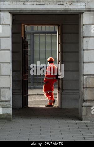 Travailleur de la construction debout à la porte d'entrée d'un bâtiment historique Londres Banque D'Images