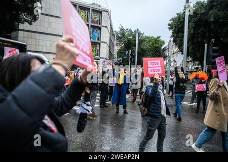 Tel Aviv, Israël. 24 janvier 2024. Les femmes israéliennes chantent et brandissent des pancartes alors qu'elles bloquent une jonction lors d'une manifestation demandant un accord immédiat sur les otages et un cessez-le-feu. 136 otages israéliens sont toujours détenus en captivité par le Hamas à Gaza, dans des conditions potentiellement mortelles depuis l'attaque du 7 octobre. Crédit : SOPA Images Limited/Alamy Live News Banque D'Images