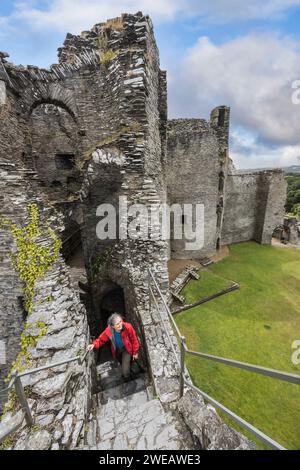 Femme visiteuse montant des escaliers dans la ruine du château de Cilgerran, Pembrokeshire, pays de Galles, Royaume-Uni Banque D'Images