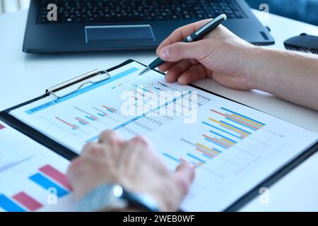 Homme comptable mains avec stylo analysant le rapport d'entreprise et les données boursières. Concept commercial et paperasserie. Banque D'Images