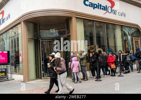 Les participants font la queue pour entrer dans l’inauguration d’une succursale du Capital One Cafe à Herald Square à New York, le samedi 20 janvier 2024. En plus d'avoir une succursale de la banque enterrée à l'intérieur, le café accueillant sert de la nourriture et des boissons et sert d'espace de co-working, que vous soyez client ou non. (© Richard B. Levine) Banque D'Images