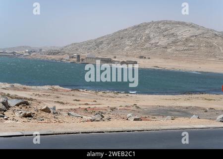 Paysage urbain avec des bâtiments industriels délabrés sur le rivage à Agate Beach, tourné dans la lumière brillante de la fin du printemps à Luderitz, Namibie, Afrique Banque D'Images