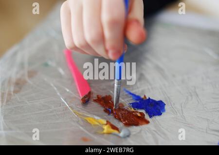 femmes mélangeant à la main des peintures acryliques Banque D'Images