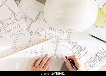 Vue de dessus d'un architecte mains travaillant sur des plans d'architecture sur le bureau Banque D'Images