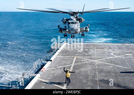 Aviation Boatswain soutient Aviation Boatswain's Mate lorsqu'il signale un hélicoptère CH-53E Super Stallion affecté aux « White Knights » du Marine Medium Tiltrotor Squadron (VMM) 165 (renforcé) pendant les quarts de vol à bord du navire amphibie de transport USS Somerset (LPD 25) de classe San Antonio alors qu'il se dirigeait dans l'océan Pacifique Banque D'Images