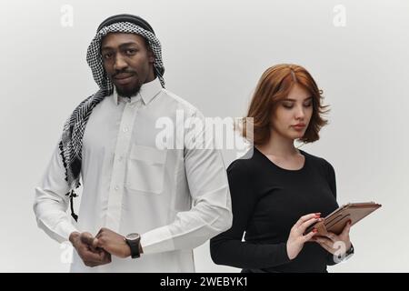 Entrepreneur arabe et femme d’affaires, exsudant confiance et unité, posent ensemble sur un fond blanc propre, symbolisant un partenariat dynamique Banque D'Images