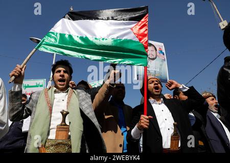 Sanaa, Sanaa, Yémen. 24 janvier 2024. Des manifestants brandissent des drapeaux palestiniens lors d'une manifestation contre les frappes aériennes soutenues menées par les États-Unis sur le Yémen, et en solidarité avec le peuple palestinien dans un conflit en cours entre Israël et le Hamas à Gaza.le porte-parole militaire houthi Yahya Saree a rapporté une confrontation entre leurs forces et plusieurs destroyers et navires de guerre américains dans le golfe d'Aden et Bab al-Mandab aujourd'hui. Les navires américains gardaient deux navires commerciaux, et pendant l'affrontement, l'un des navires américains a été frappé. En conséquence, les deux navires marchands américains ont été contraints Banque D'Images