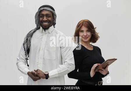 Entrepreneur arabe et femme d’affaires, exsudant confiance et unité, posent ensemble sur un fond blanc propre, symbolisant un partenariat dynamique Banque D'Images