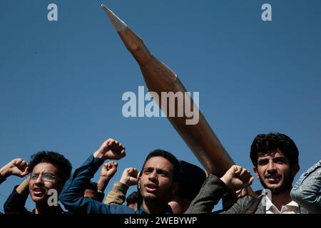 Sanaa, Sanaa, Yémen. 24 janvier 2024. Des manifestants brandissent un faux missile alors qu'ils participaient à une manifestation organisée contre les frappes aériennes soutenues menées par les États-Unis sur le Yémen, et en solidarité avec les Palestiniens à Sanaa, Yémen. le porte-parole militaire houthi Yahya Saree a rapporté une confrontation entre leurs forces et plusieurs destroyers et navires de guerre américains dans le golfe d'Aden et Bab al-Mandab aujourd'hui. Les navires américains gardaient deux navires commerciaux, et pendant l'affrontement, l'un des navires américains a été frappé. En conséquence, les deux navires marchands américains ont été contraints de battre en retraite et de revenir en arrière Banque D'Images