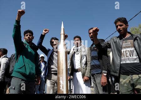 Sanaa, Sanaa, Yémen. 24 janvier 2024. Les manifestants tiennent un faux missile alors qu'ils participaient à une manifestation organisée contre les frappes aériennes soutenues menées par les États-Unis sur le Yémen, et en solidarité avec les Palestiniens à Sanaa, Yémen. le porte-parole militaire houthi Yahya Saree a rapporté une confrontation entre leurs forces et plusieurs destroyers et navires de guerre américains dans le golfe d'Aden et Bab al-Mandab aujourd'hui. Les navires américains gardaient deux navires commerciaux, et pendant l'affrontement, l'un des navires américains a été frappé. En conséquence, les deux navires marchands américains ont été contraints de battre en retraite et de revenir en arrière. ( Banque D'Images