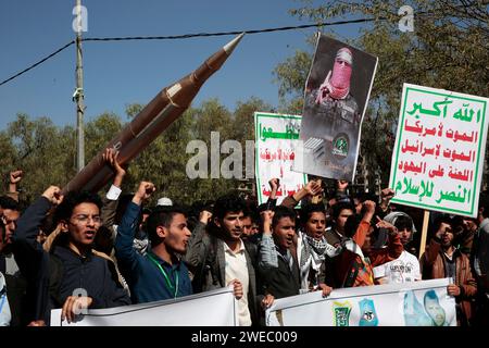 Sanaa, Sanaa, Yémen. 24 janvier 2024. Des manifestants brandissent un faux missile alors qu'ils participaient à une manifestation organisée contre les frappes aériennes soutenues menées par les États-Unis sur le Yémen, et en solidarité avec les Palestiniens à Sanaa, Yémen. le porte-parole militaire houthi Yahya Saree a rapporté une confrontation entre leurs forces et plusieurs destroyers et navires de guerre américains dans le golfe d'Aden et Bab al-Mandab aujourd'hui. Les navires américains gardaient deux navires commerciaux, et pendant l'affrontement, l'un des navires américains a été frappé. En conséquence, les deux navires marchands américains ont été contraints de battre en retraite et de revenir en arrière Banque D'Images