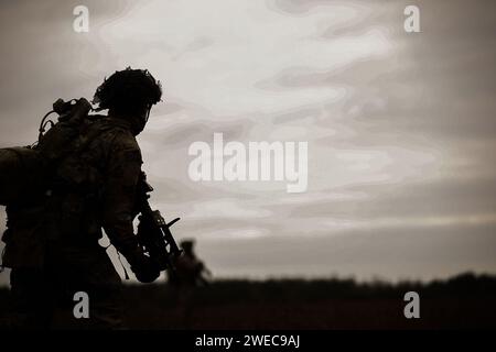 Soldat américain affecté à la compagnie des bandits, 3e bataillon, 15e régiment d'infanterie, 2e brigade blindée équipe de combat, 3e division d'infanterie, manoeuvres sur le champ de tir au cours d'un exercice de tir réel à Karliki, Pologne, 23 janvier 2024. La mission de la 3e Division d’infanterie en Europe est de s’engager dans des entraînements et des exercices multinationaux à travers le continent, en travaillant aux côtés des alliés de l’OTAN et des partenaires de sécurité régionaux pour fournir des forces crédibles au combat au V corps, le corps avancé déployé des États-Unis en Europe. (Photo de l'armée américaine par le sergent Michael Udejiofor) Banque D'Images