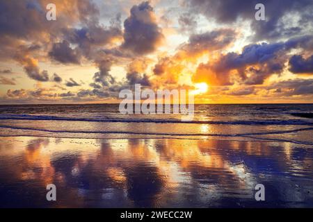 Ciel avec des nuages colorés reflétés dans les vasières au coucher du soleil, Allemagne, Basse-Saxe, Norderney Banque D'Images