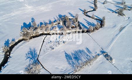 Drone shot de la rivière Schmutter serpentant naturellement à travers le paysage hivernal enneigé du parc naturel Western Forests près d'Augsbourg Banque D'Images